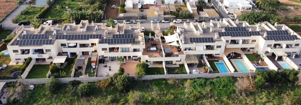 Hilera de viviendas adosadas con paneles solares en sus cubiertas, vista aérea
