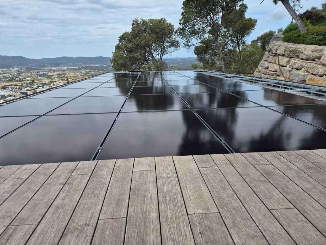 Paneles solares en la cubierta de una vivienda con vistas al valle